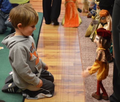 Young audience member gets a close-up look at the minstrel marionette