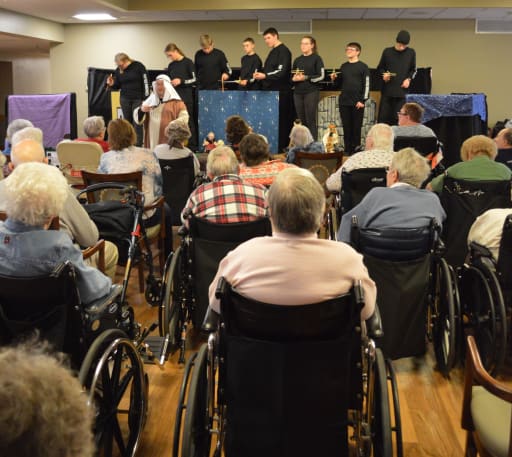 elderly residents of a local care facility watch the marionettes