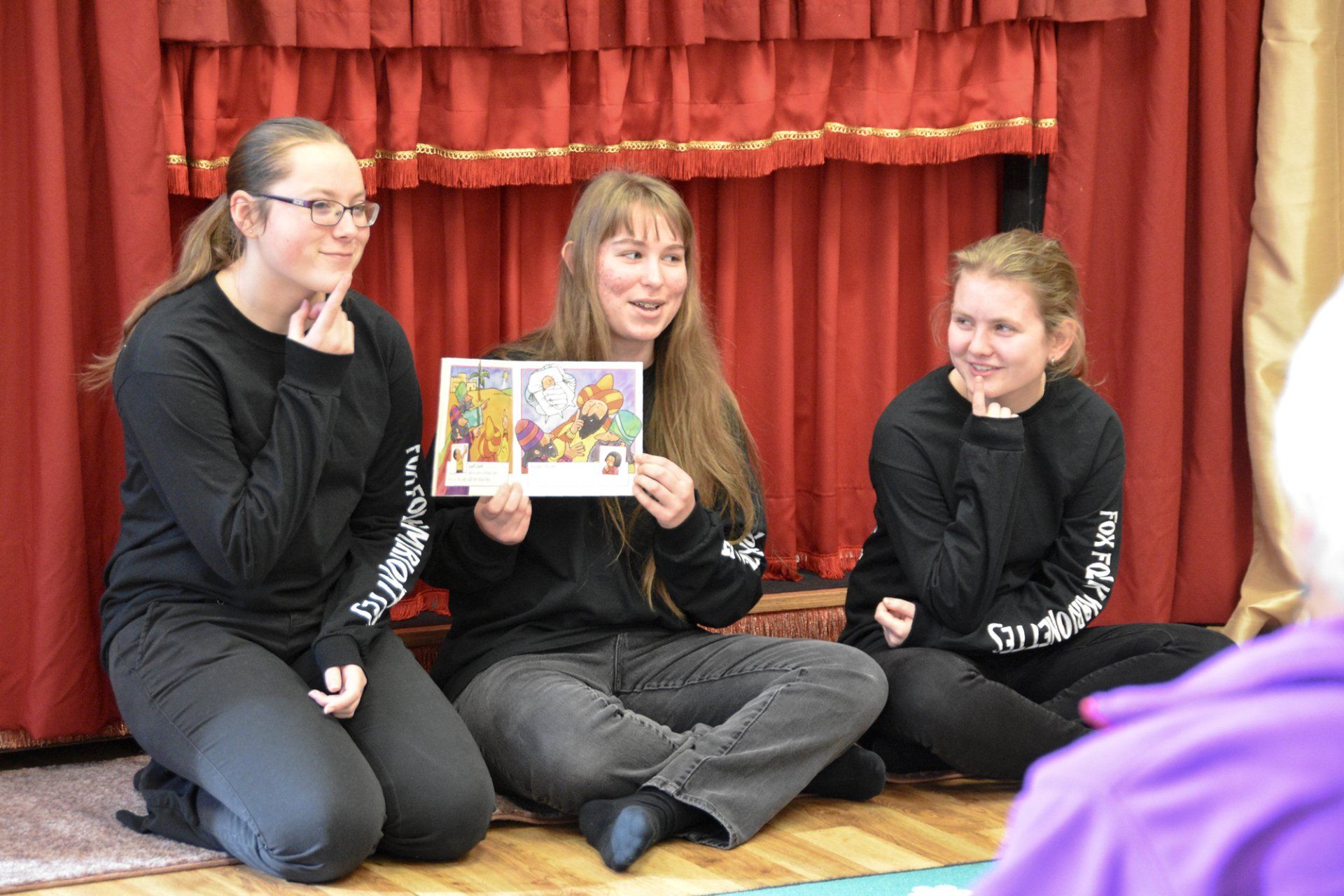 Three puppeteers reading to our audience