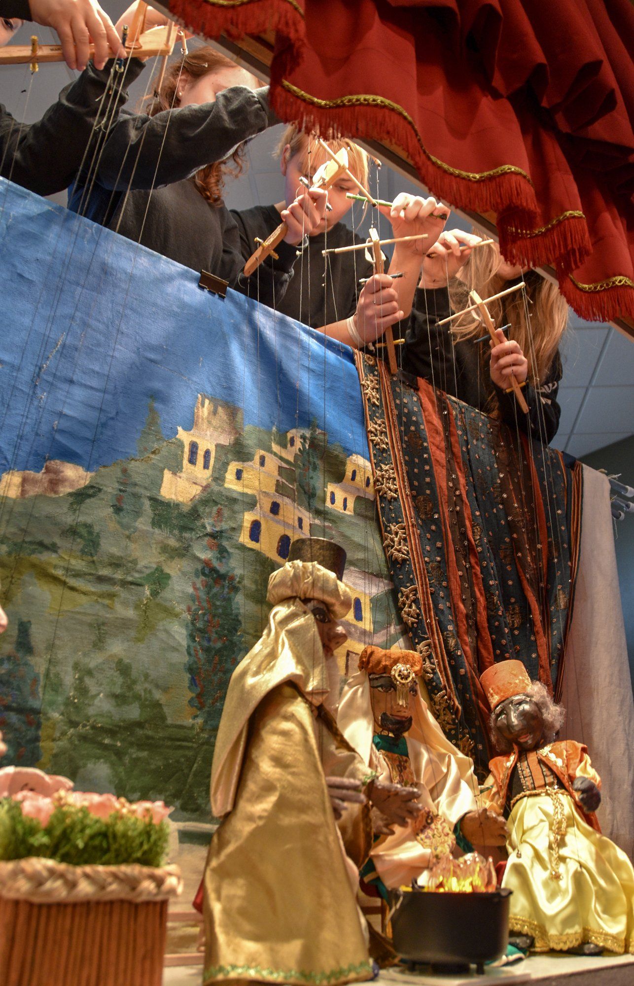 Unique perspective looking up from the puppets to the marionettists working the strings