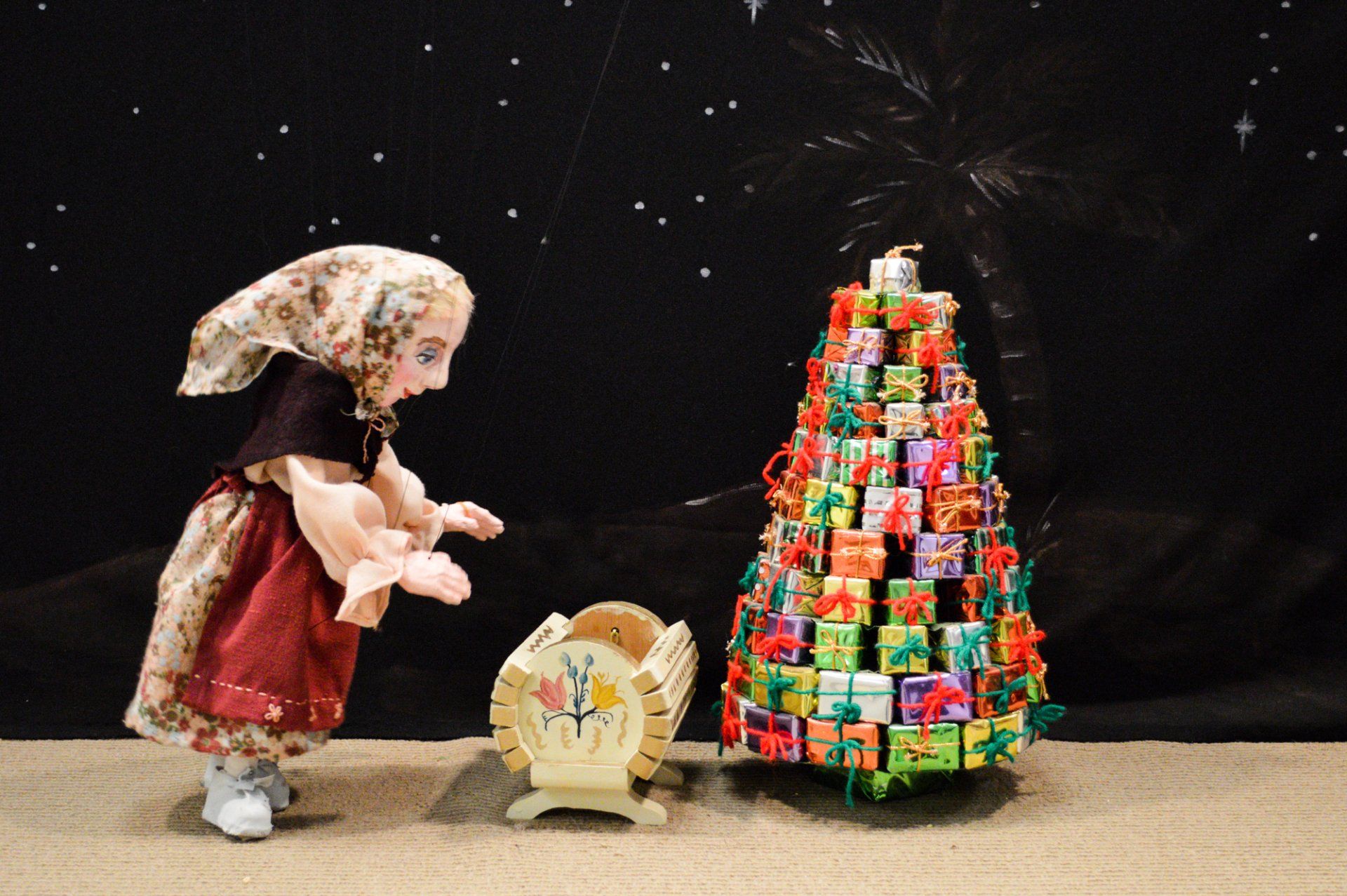 Baboushka marionette bends down to cradle