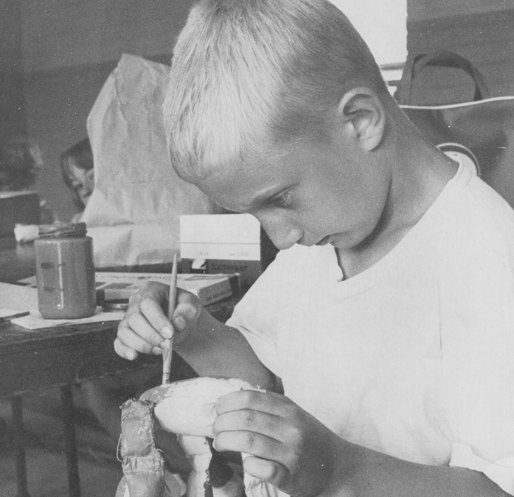 Mr. Dave works carefully on his marionette creation as a young boy