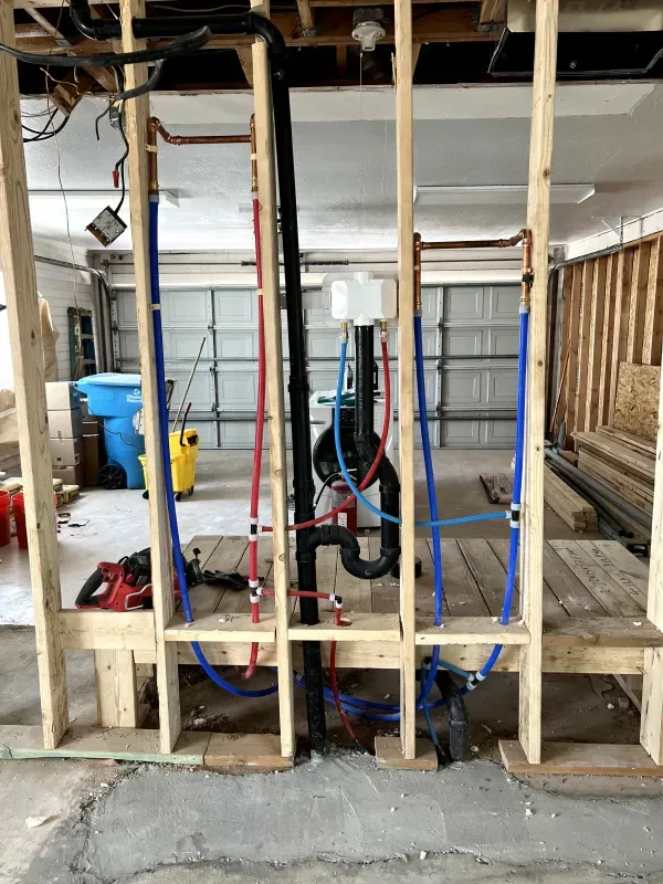 A building under construction with a lot of pipes coming out of it.