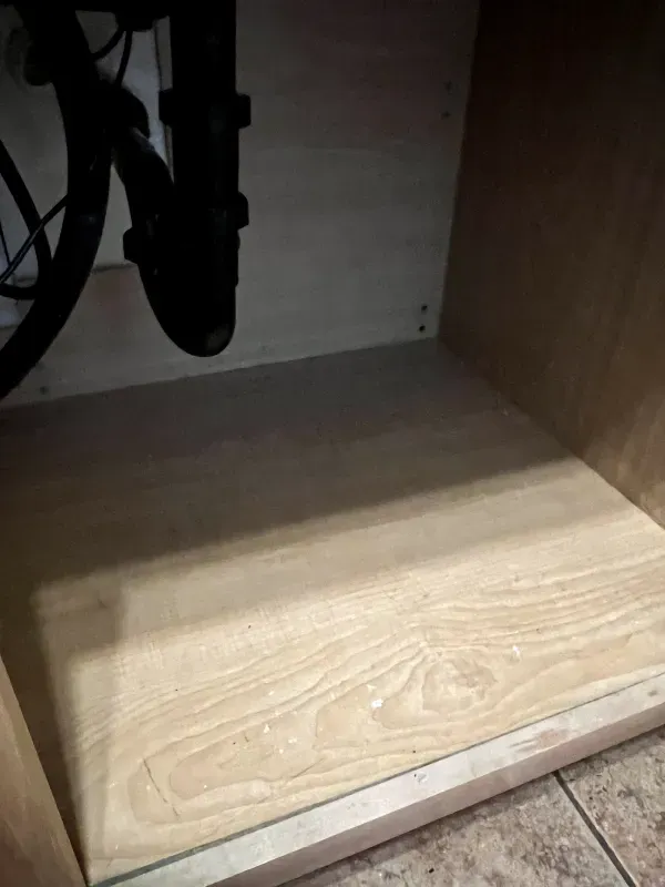 A sink with a wooden floor underneath it.