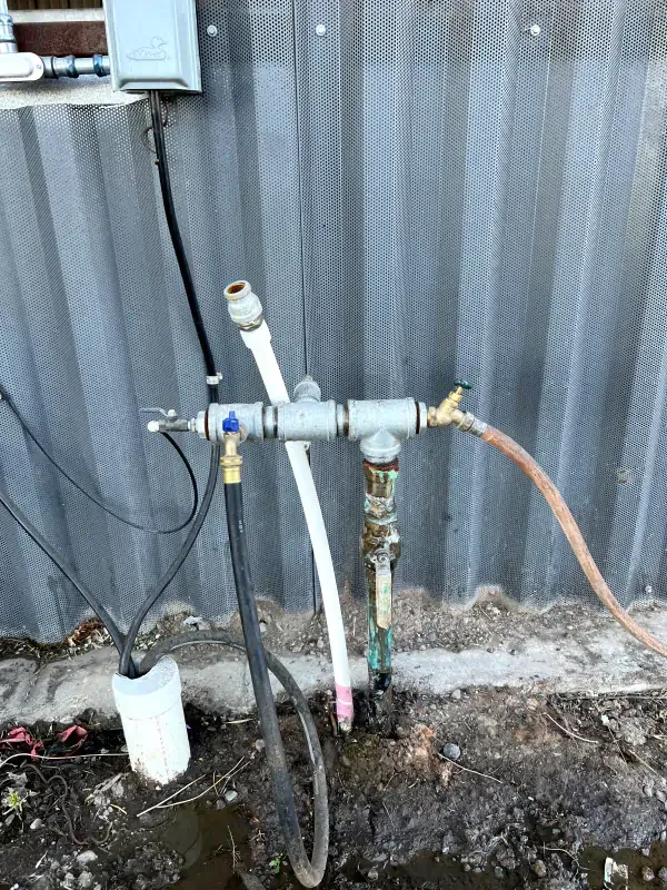 A hose is attached to a faucet on the side of a building.