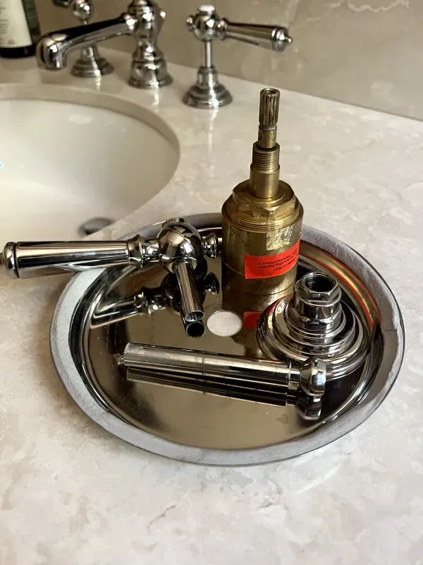 A tray with a faucet on it is on a counter next to a sink.