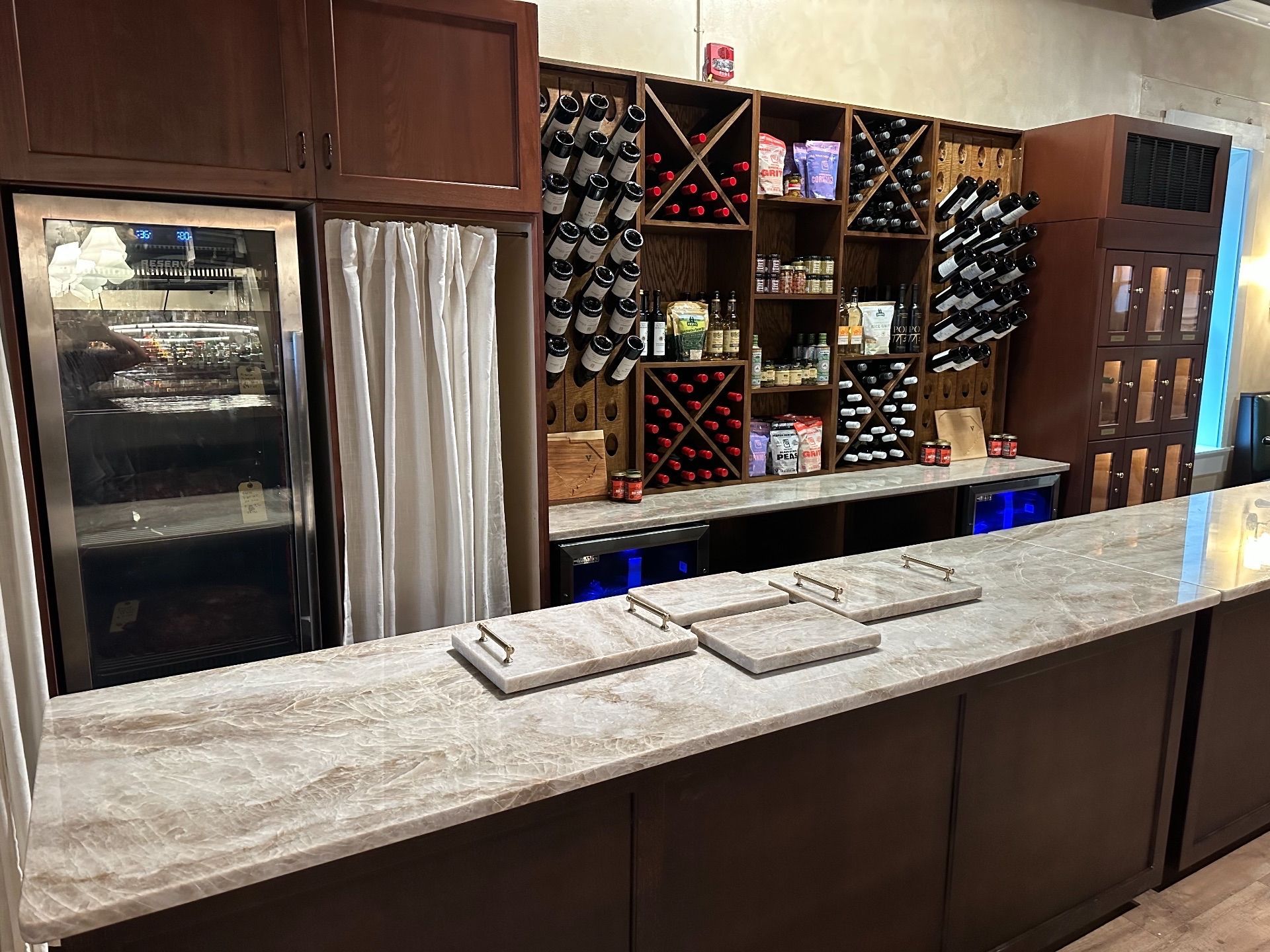 Wine bar interior with wooden cabinetry, wine racks, and a long countertop.
