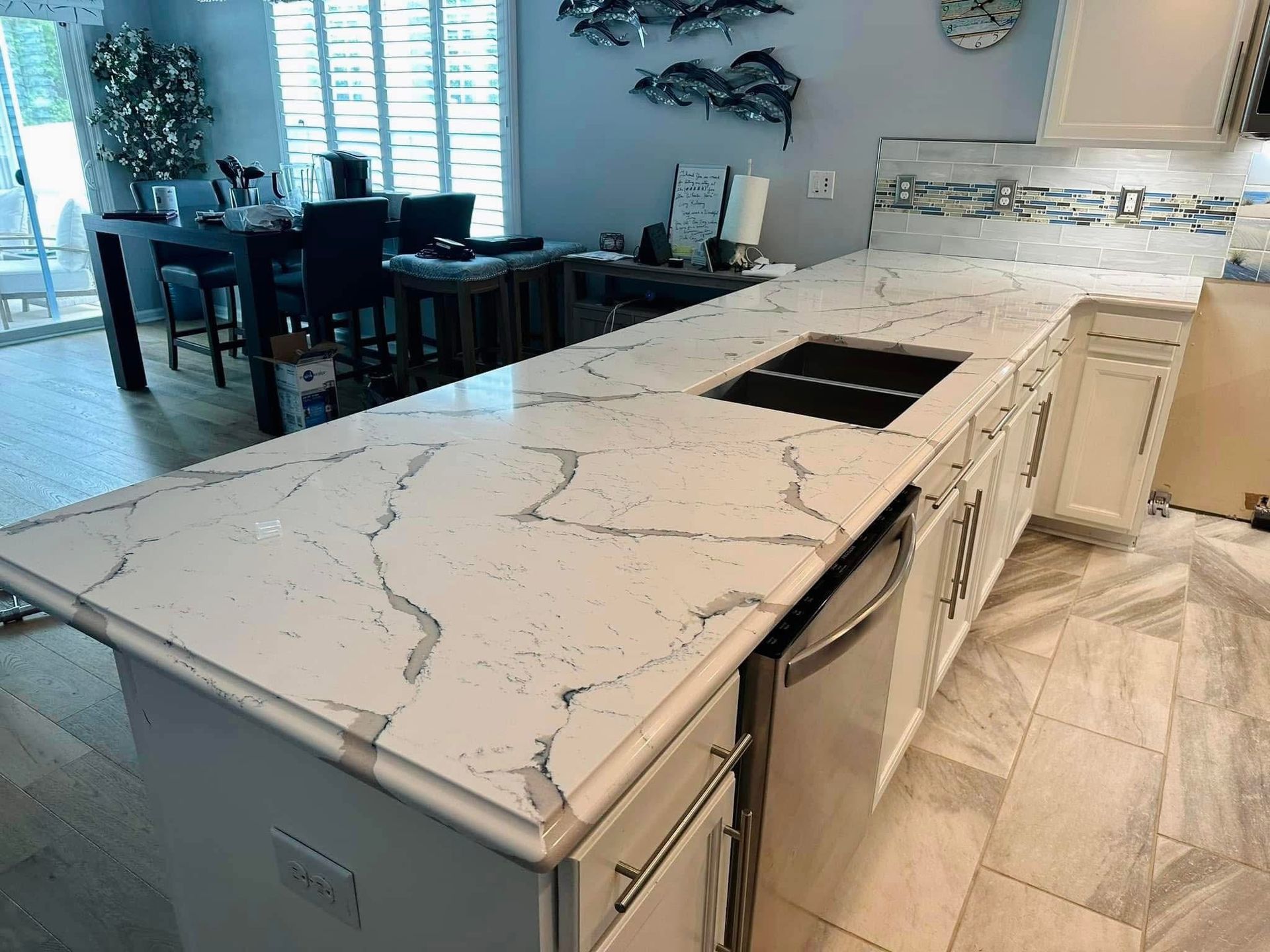 Kitchen with white cabinets, quartz countertop, and a built-in cooktop.