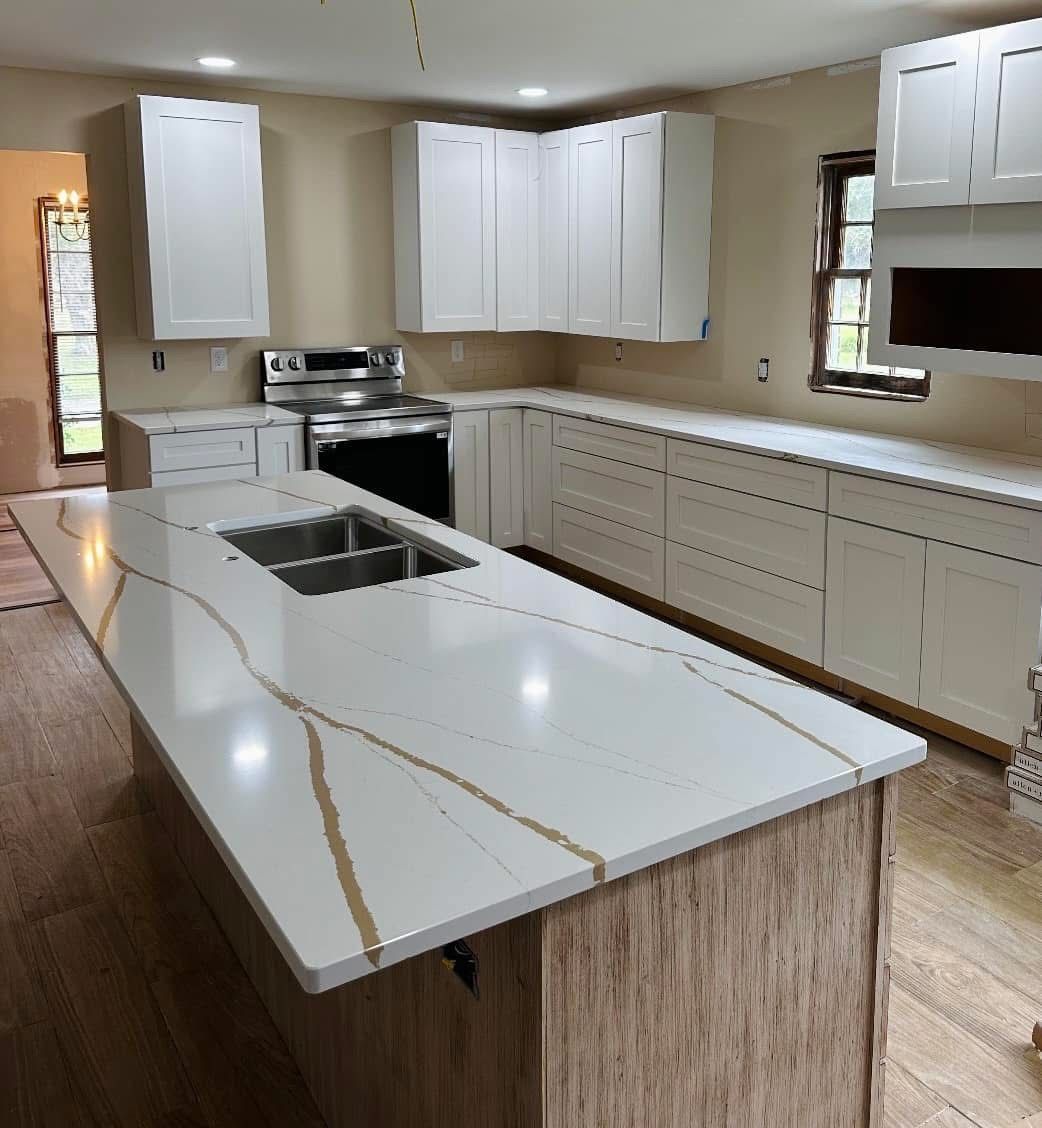 Newly renovated kitchen with white cabinets, quartz countertops, and a large island.