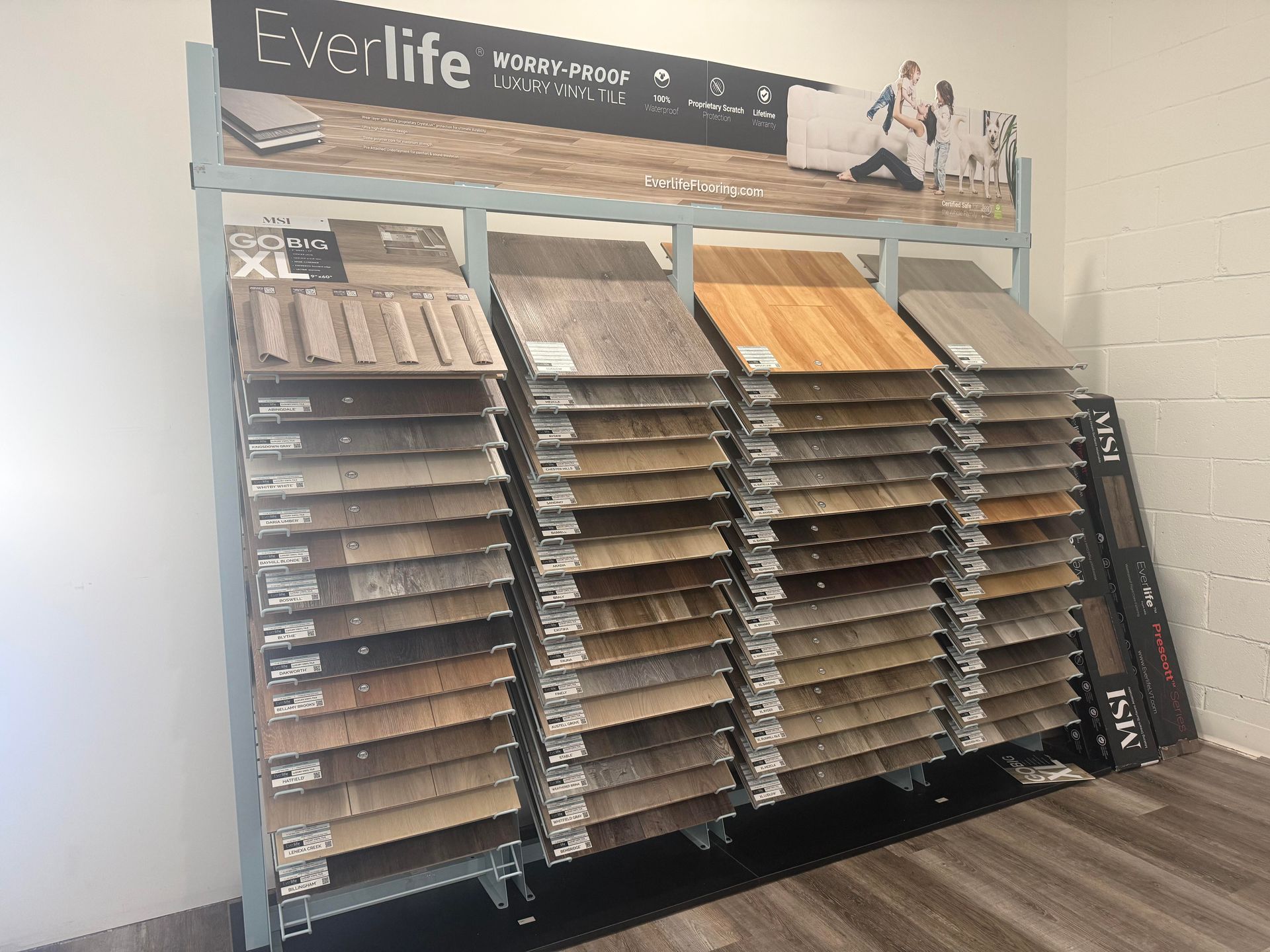 Bright white kitchen with a large island, granite countertops, and stainless steel appliances.