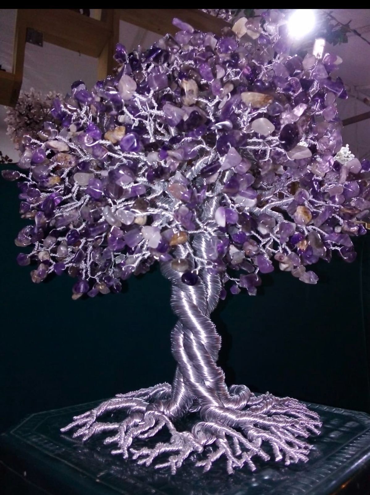 Escultura de árbol de piedra preciosa amatista con tronco y raíces de alambre de plata.