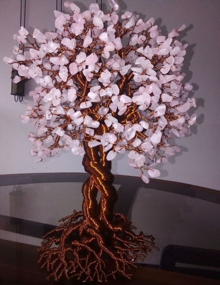 Escultura de árbol de alambre de cobre con hojas de cristal de cuarzo y tronco retorcido.