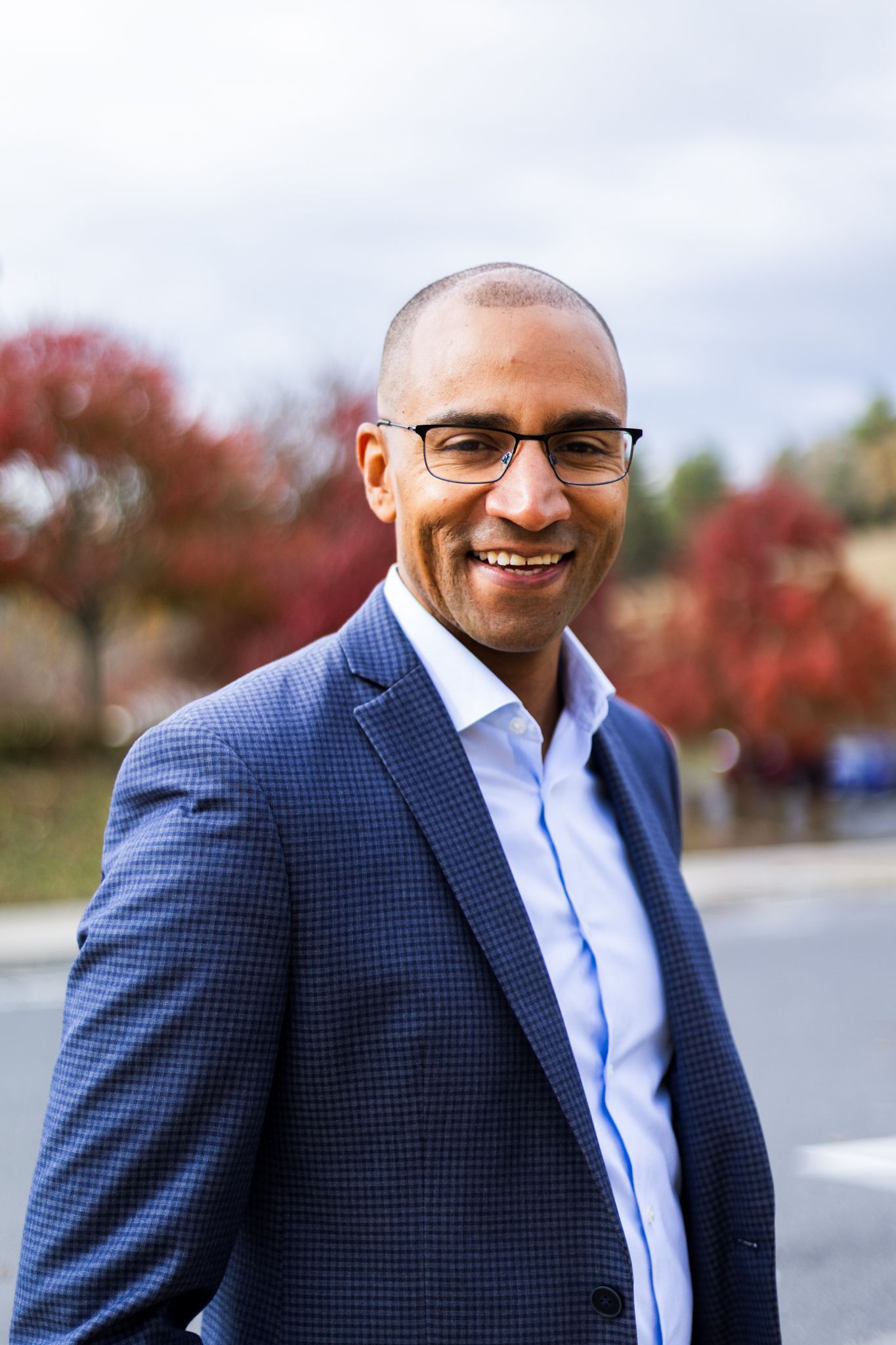 Full length professional photo of Jevon Gondwe wearing full blue suit with orange tie