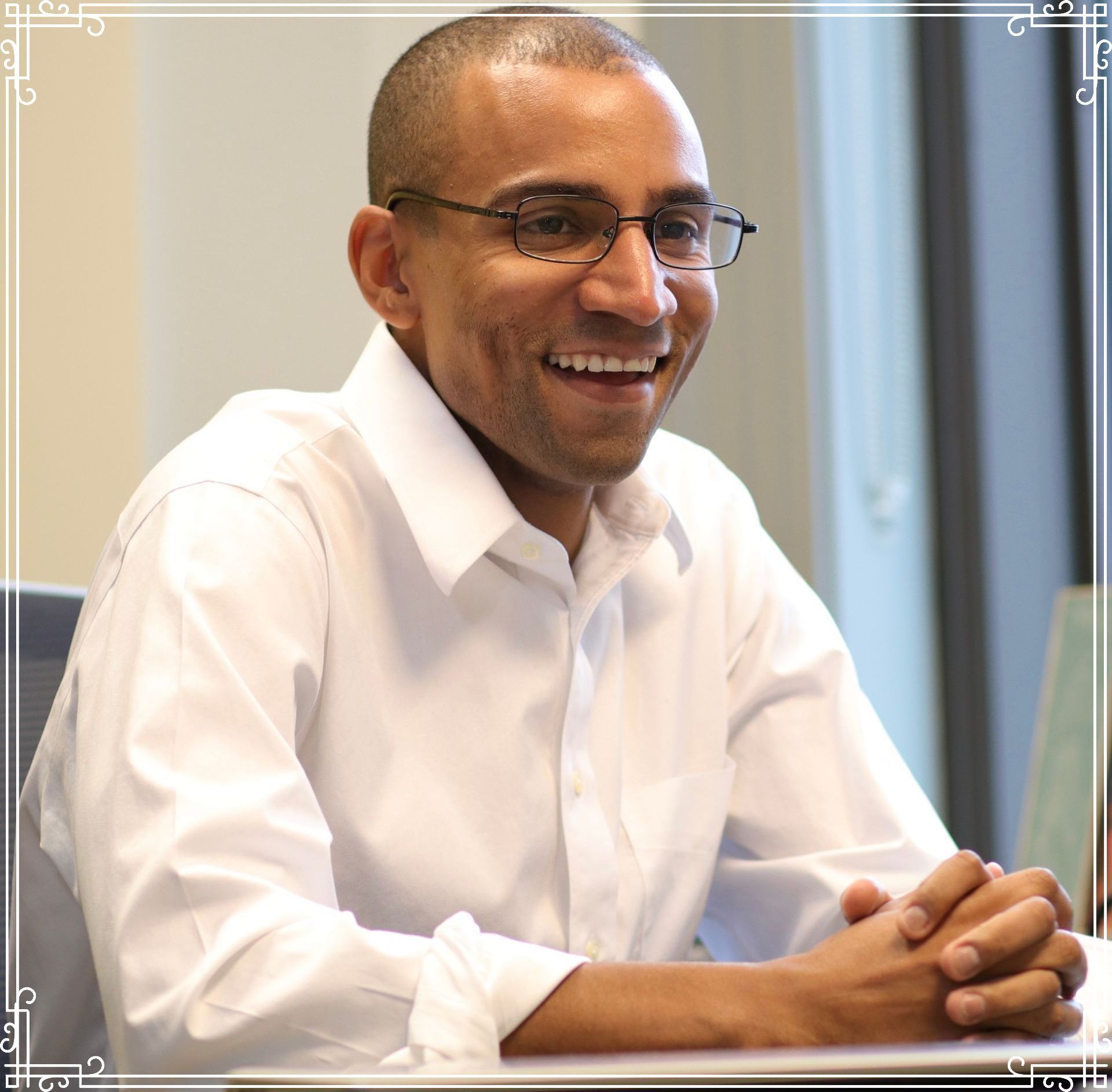 Photo of Jevon Gondwe smiling in a white collared long sleeve button down