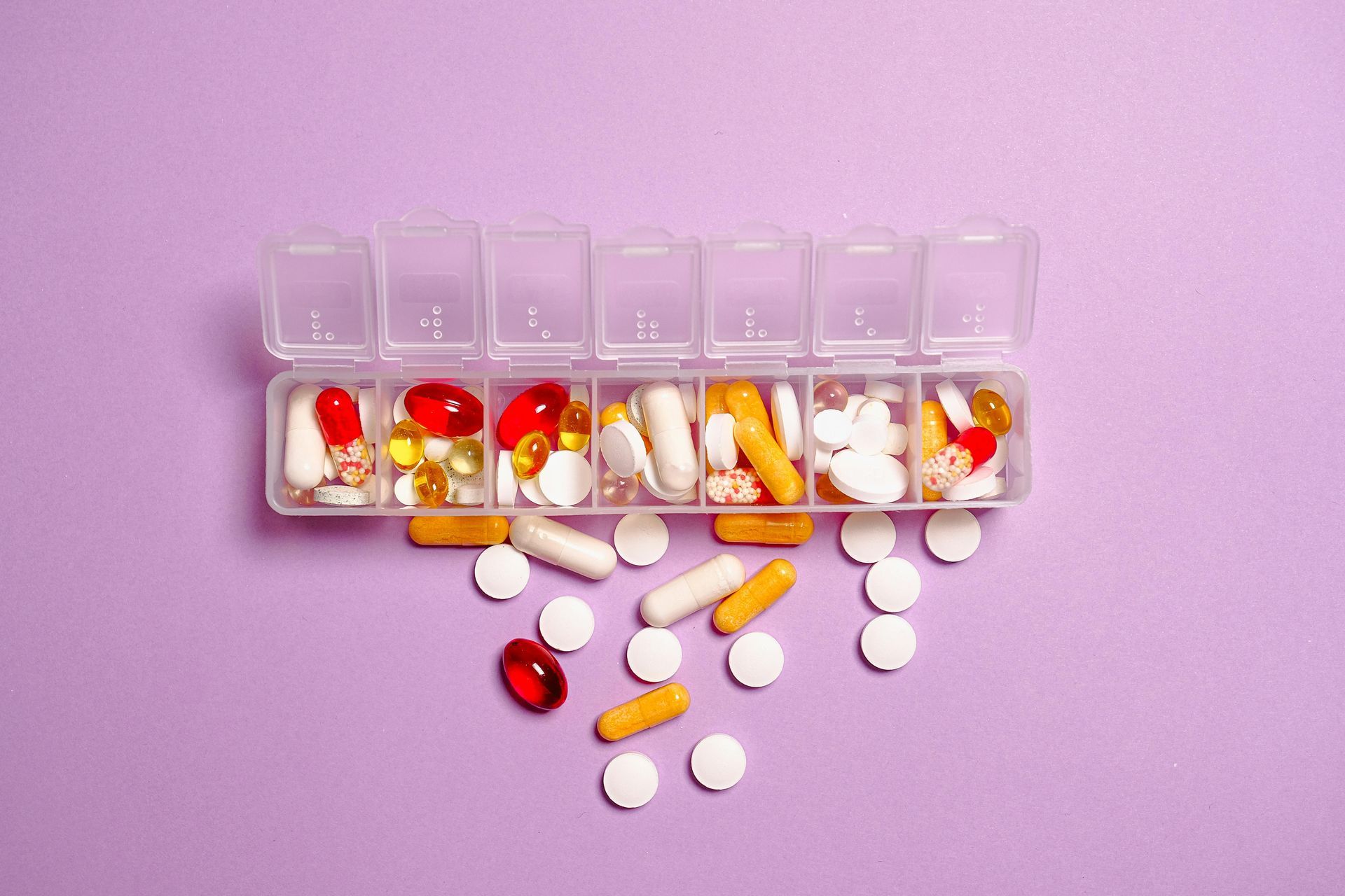A box filled with pills on a purple background.