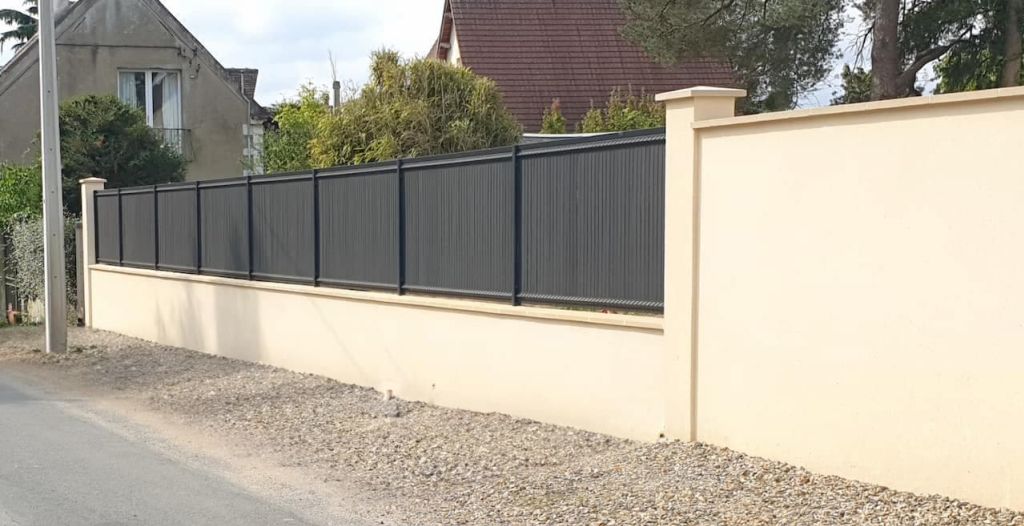 Une maison blanche avec une porte de garage blanche et une jardinière sur le côté.