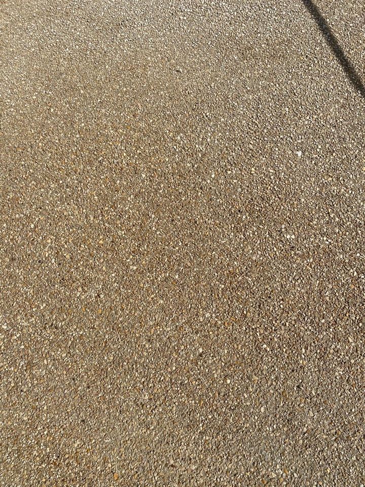 Un gros plan d'une surface en béton avec beaucoup de petites pierres dessus.