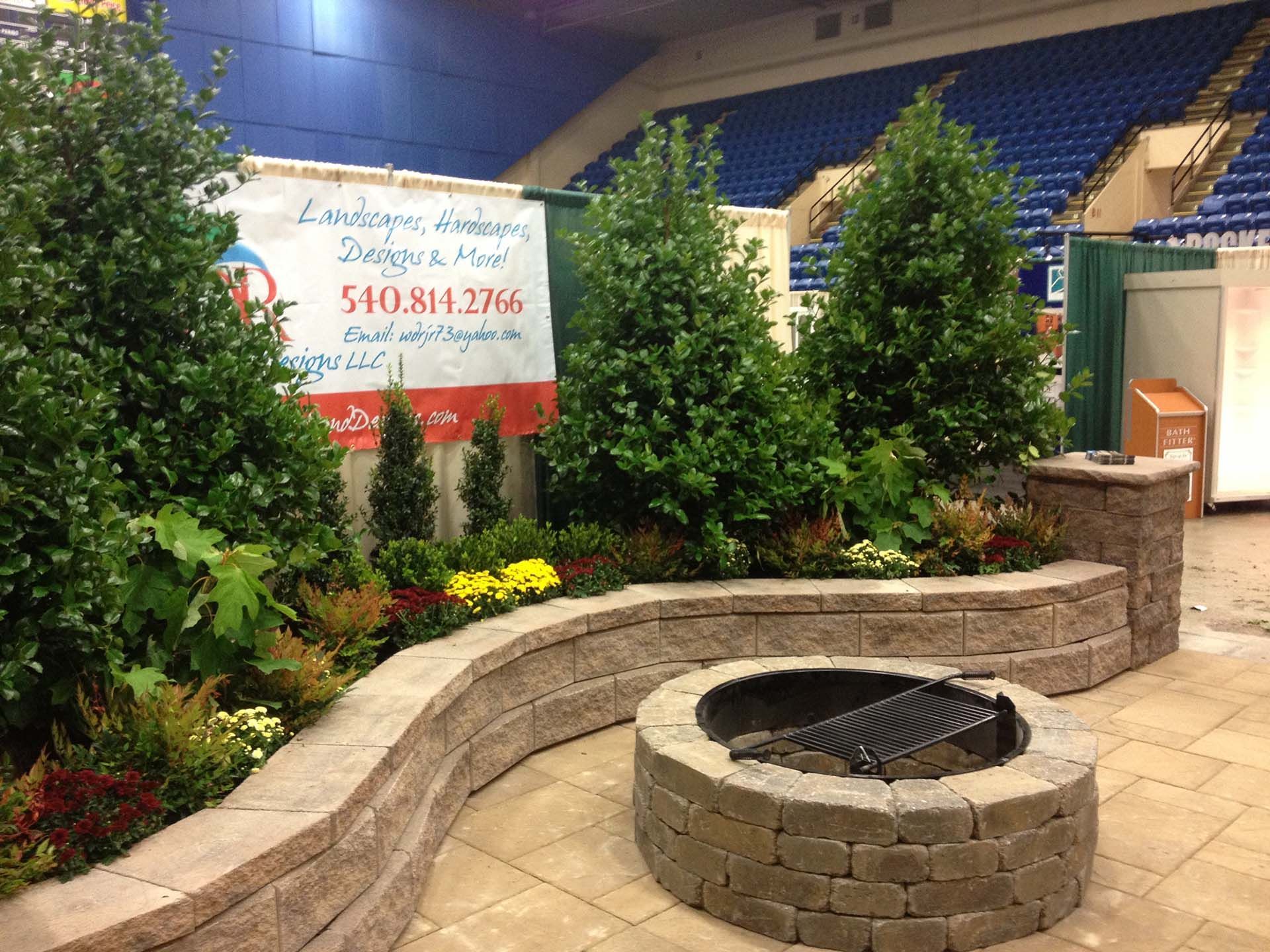 A fire pit in the middle of a lush green garden