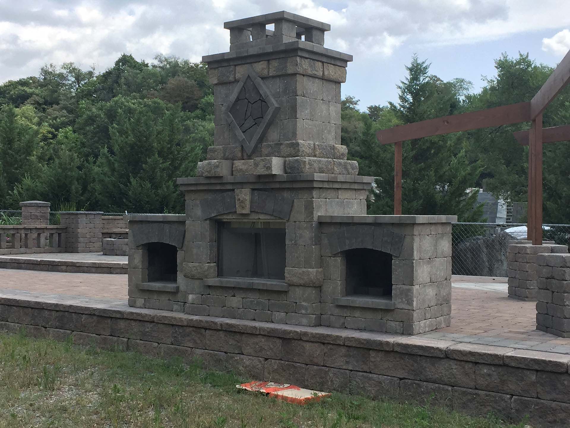 A large stone fireplace with trees in the background