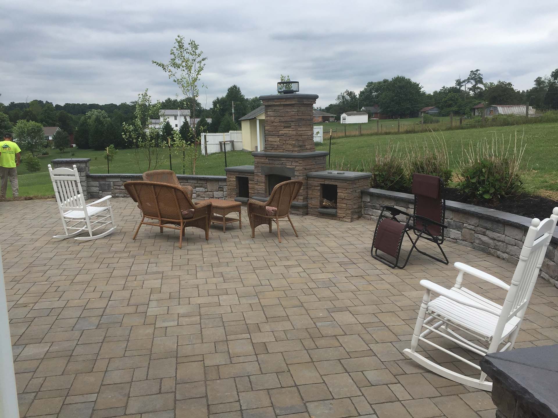 A wide patio with chairs and a fireplace