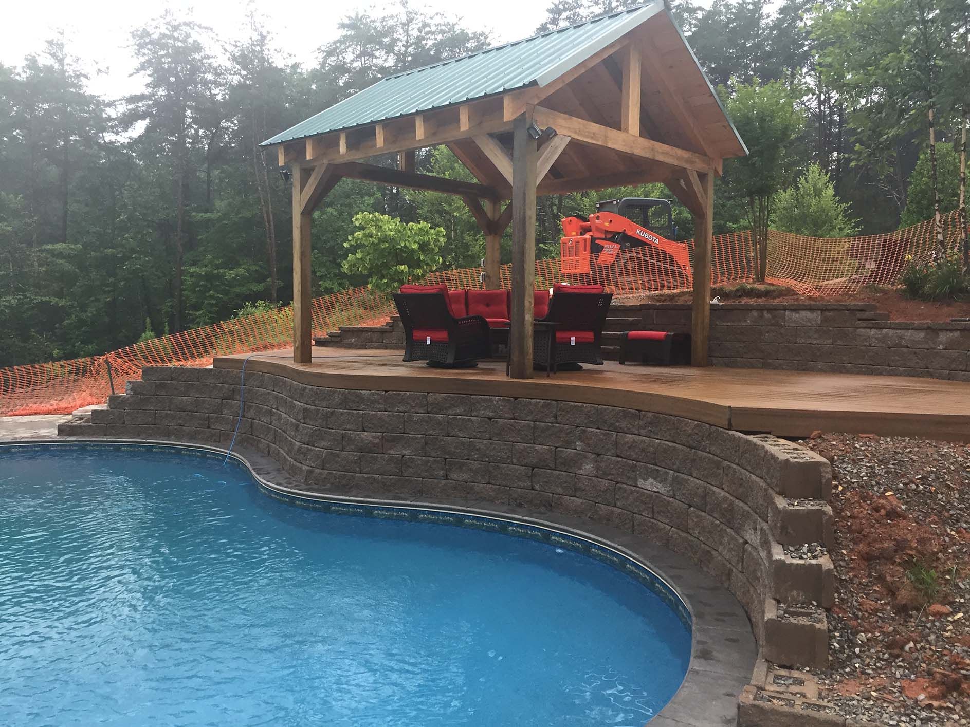 A large swimming pool with a gazebo in the background