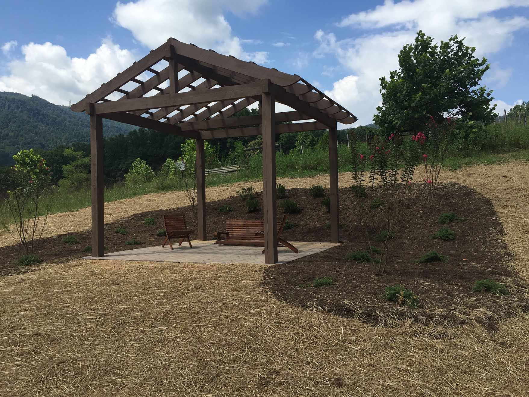 A wooden pergola with a bench underneath it