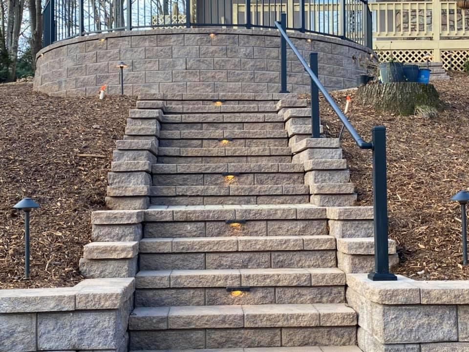 A set of stairs leading up to a brick wall with a railing