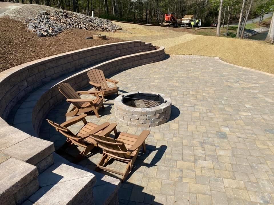 A fire pit and chairs in a wide patio