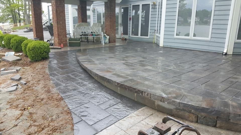 A nice patio in front of a house with glass door and windows