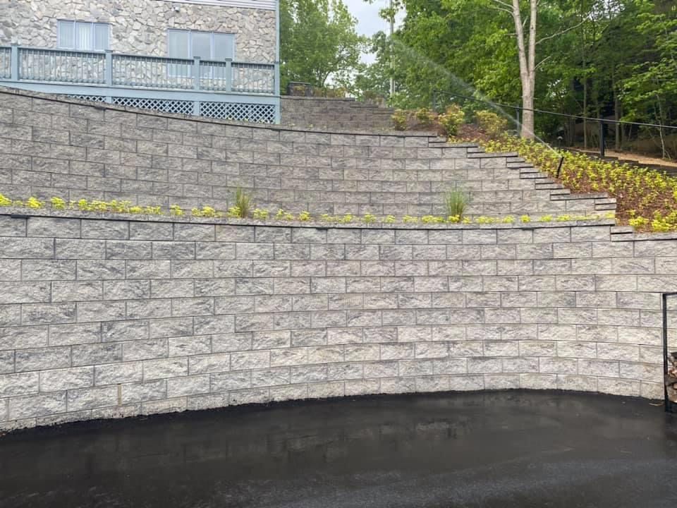 A large brick wall with stairs leading up to a house