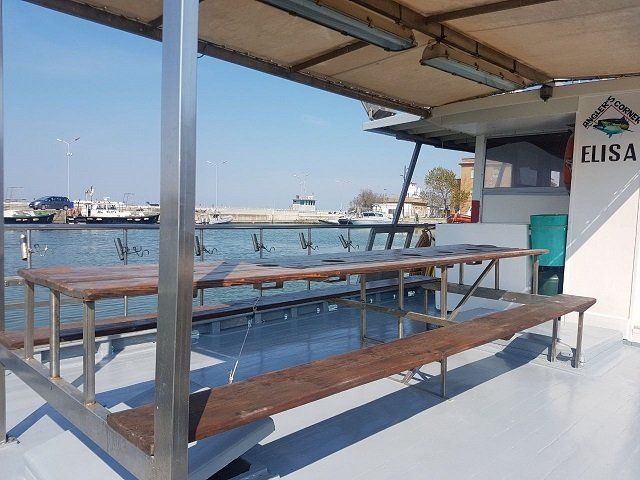 un tavolo di legno e delle panchine all'esterno di una motobarca