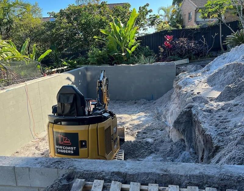 A Small Excavator is Sitting on Top of a Pile of Dirt — Norcoast Diggers in Ballina, NSW