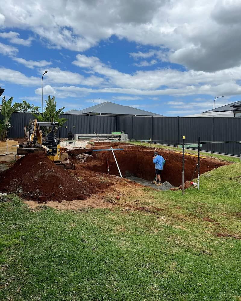 A Man is Digging a Hole in the Ground in a Backyard — Norcoast Diggers in Ballina, NSW