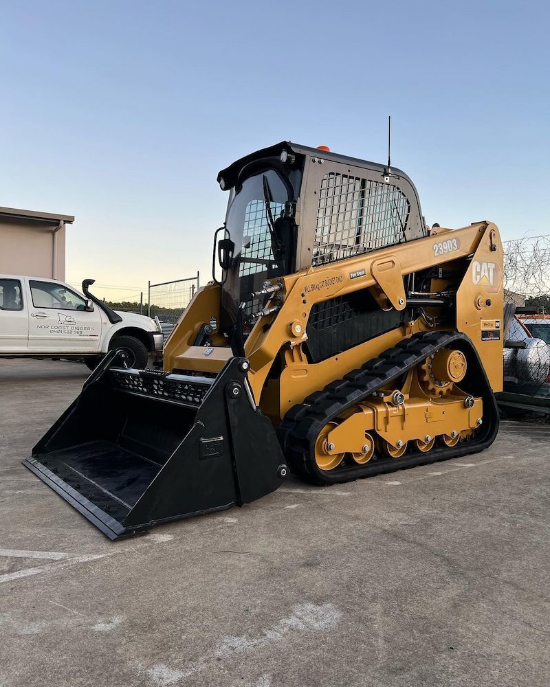 A Bulldozer is Parked in a Parking Lot Next to a Truck — Norcoast Diggers in Ballina, NSW