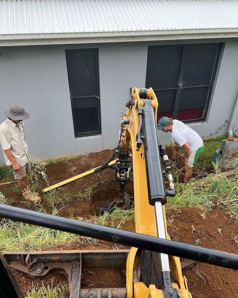 Two Men Are Digging a Hole in the Ground in Front of a House — Norcoast Diggers in Ballina, NSW