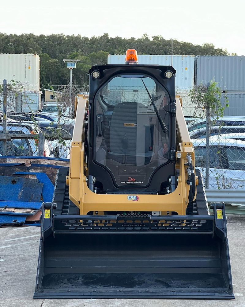 A Yellow Bobcat is parked in an empty carpark lot — Norcoast Diggers in Ballina, NSW