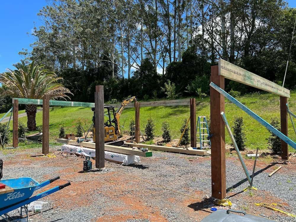 A Wooden Fence is Being Built in a Yard With a Wheelbarrow in the Foreground — Norcoast Diggers in Ballina, NSW