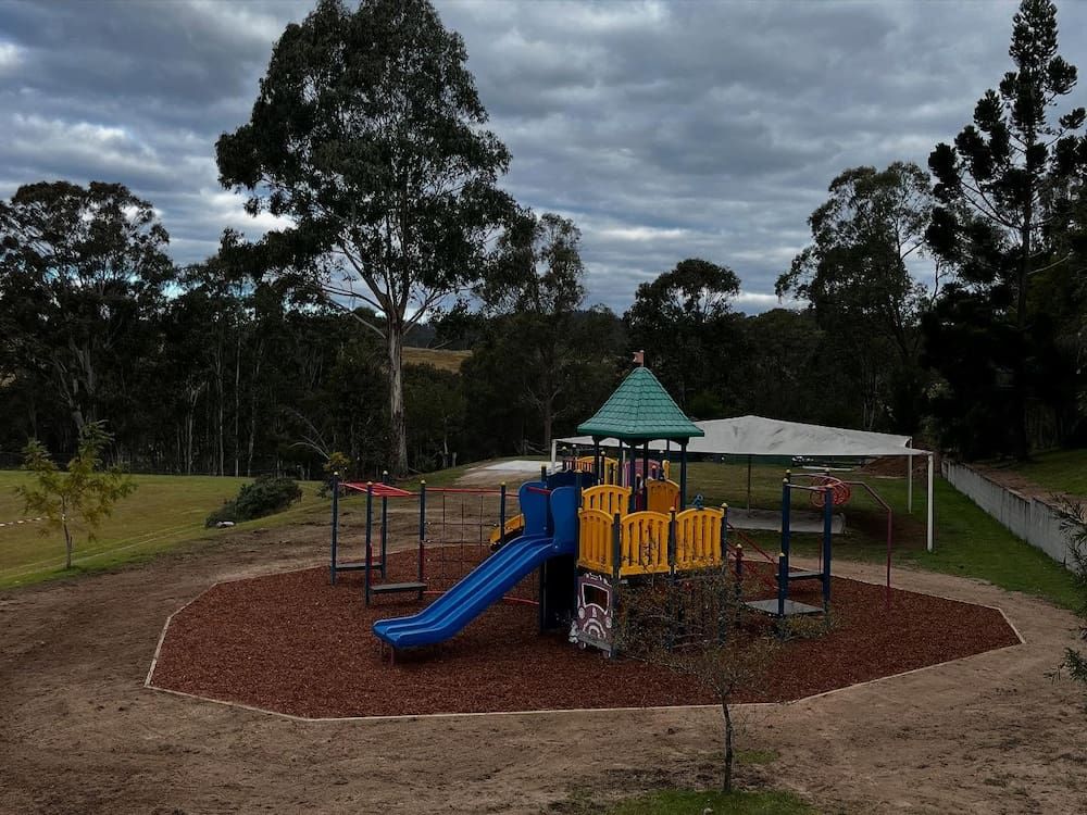 A Playground With a Slide Surrounded by Trees on a Cloudy Day — Norcoast Diggers in Ballina, NSW