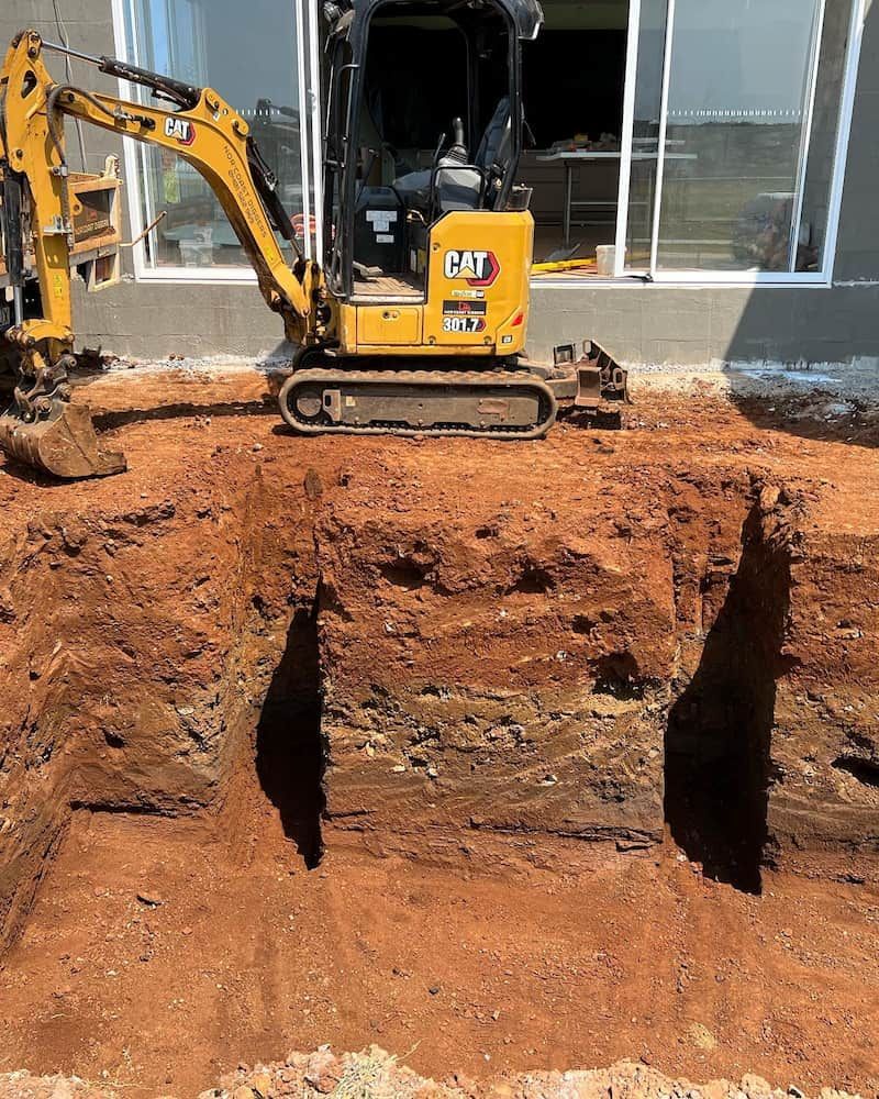 A Yellow Excavator is Digging a Hole in the Dirt — Norcoast Diggers in Ballina, NSW