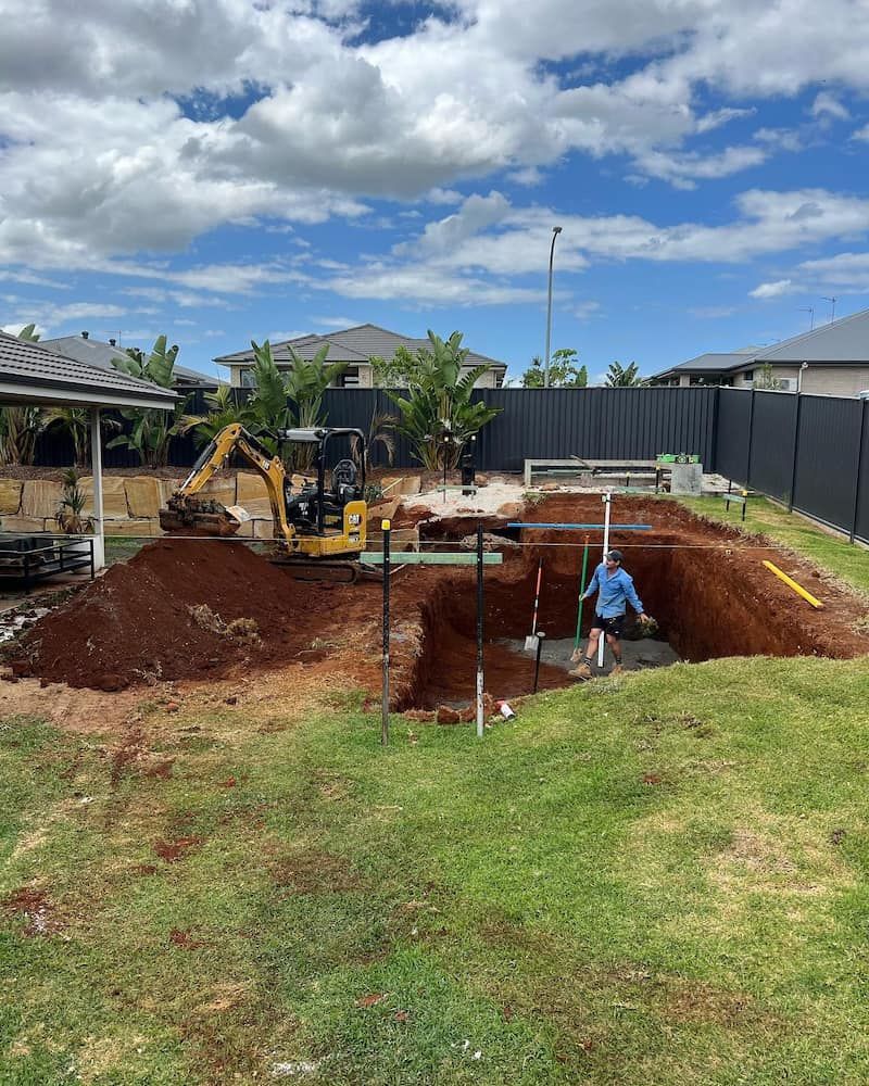 A Man is Digging a Hole in the Ground in a Backyard — Norcoast Diggers in Ballina, NSW