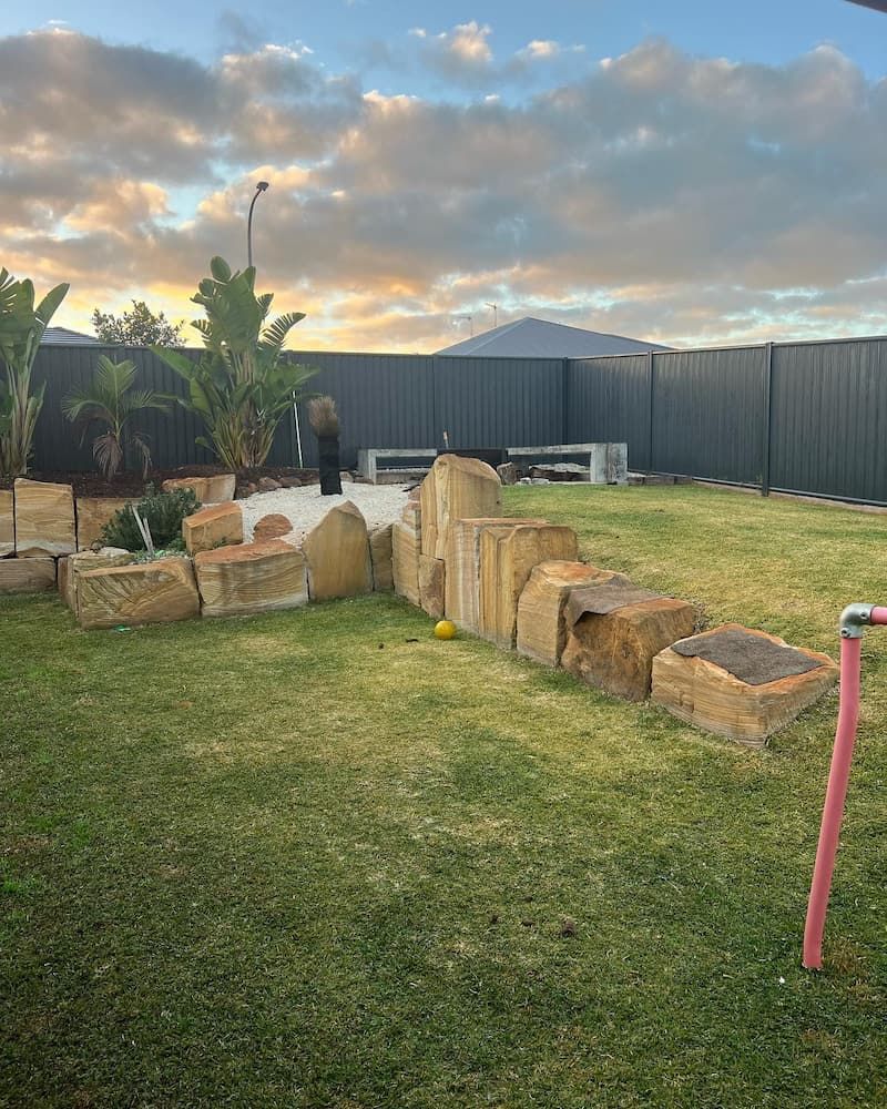 A Backyard With a Fence, Rocks, and a Pink Pipe — Norcoast Diggers in Ballina, NSW