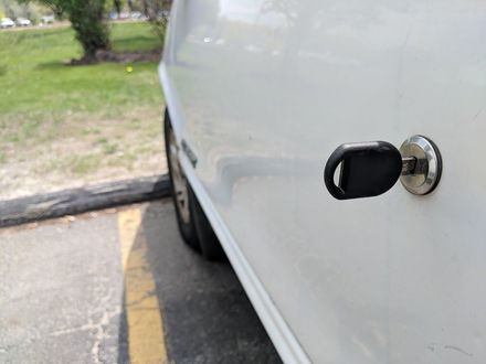 A close up of a car door with a key in it.