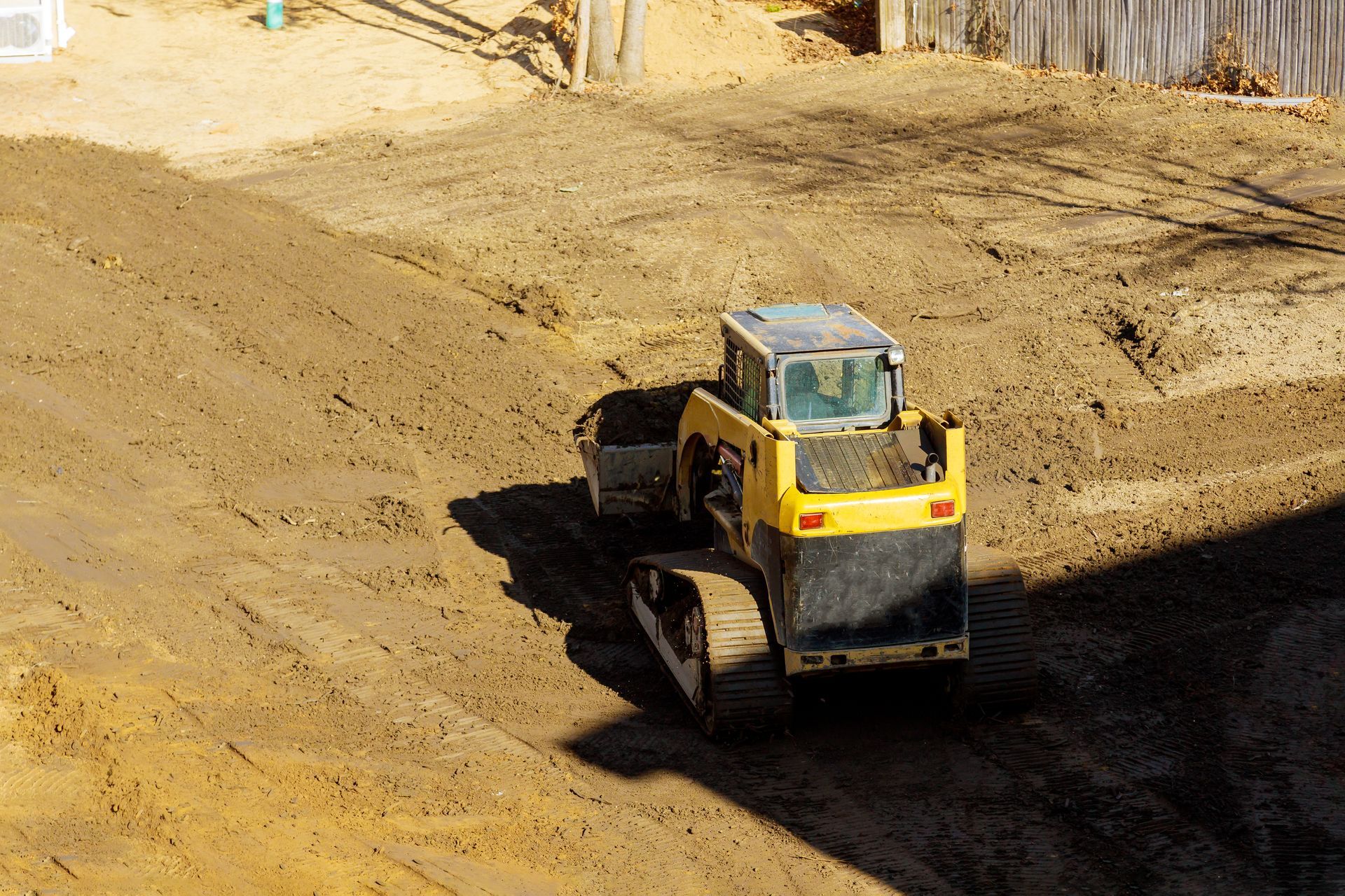 Yellow construction loader on a dirt slope at a work site