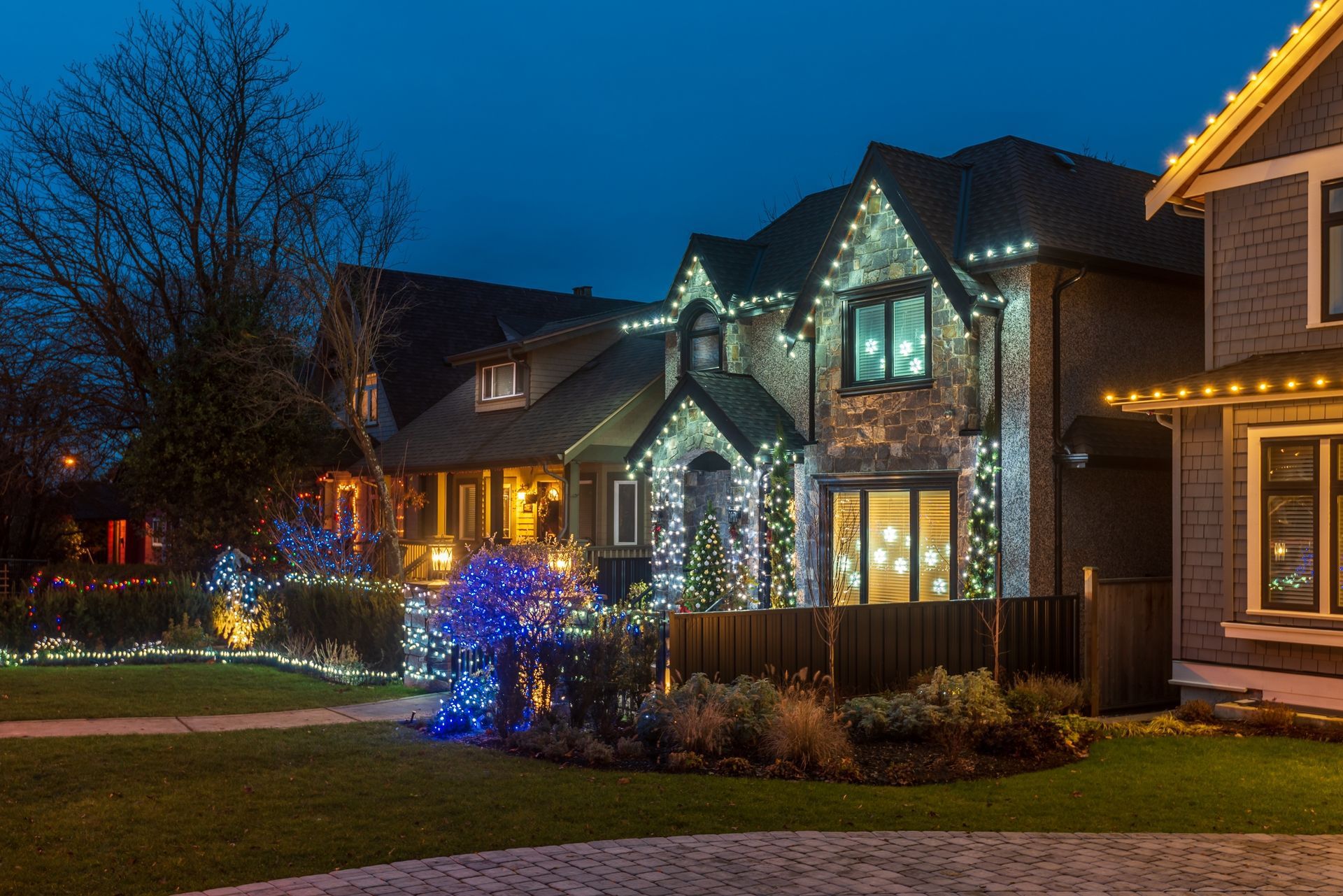 Houses decorated with Christmas lights at dusk.