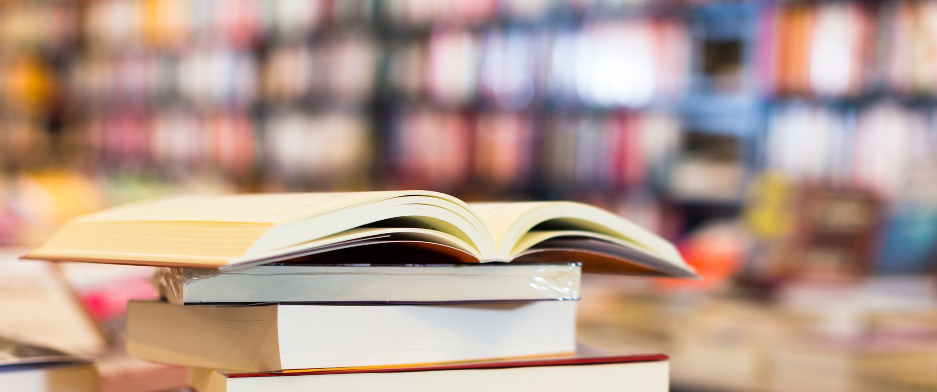 a stack of books with an open book laid out on top