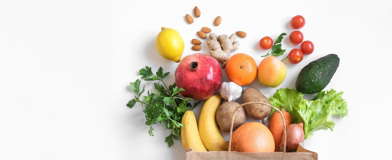 a paper bag spilling out fresh produce