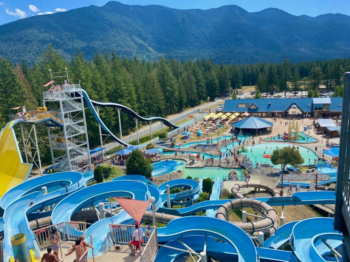 Cultus Lake Water park with blue slides, pools, and mountains in the background.