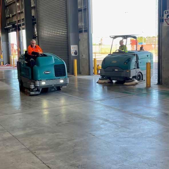 A Sweeper Truck Is Cleaning The Street With A Brush — Industrial Power Sweeping Services Pty Ltd In Knuckey Lagoon, NT