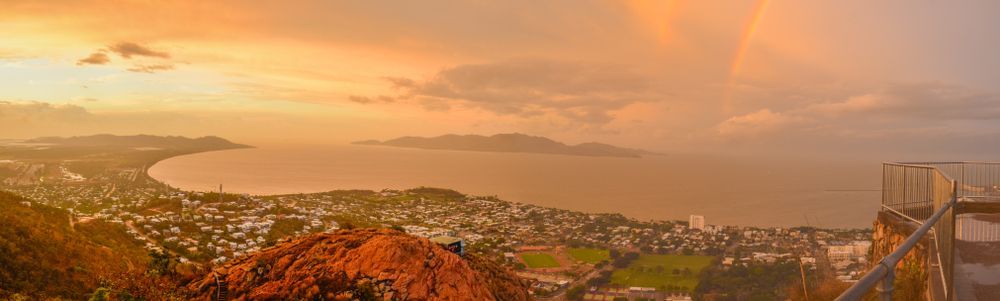 A Sunset Over A City With A Rainbow In The Sky — Law Air Conditioning In Magnetic Island, QLD
