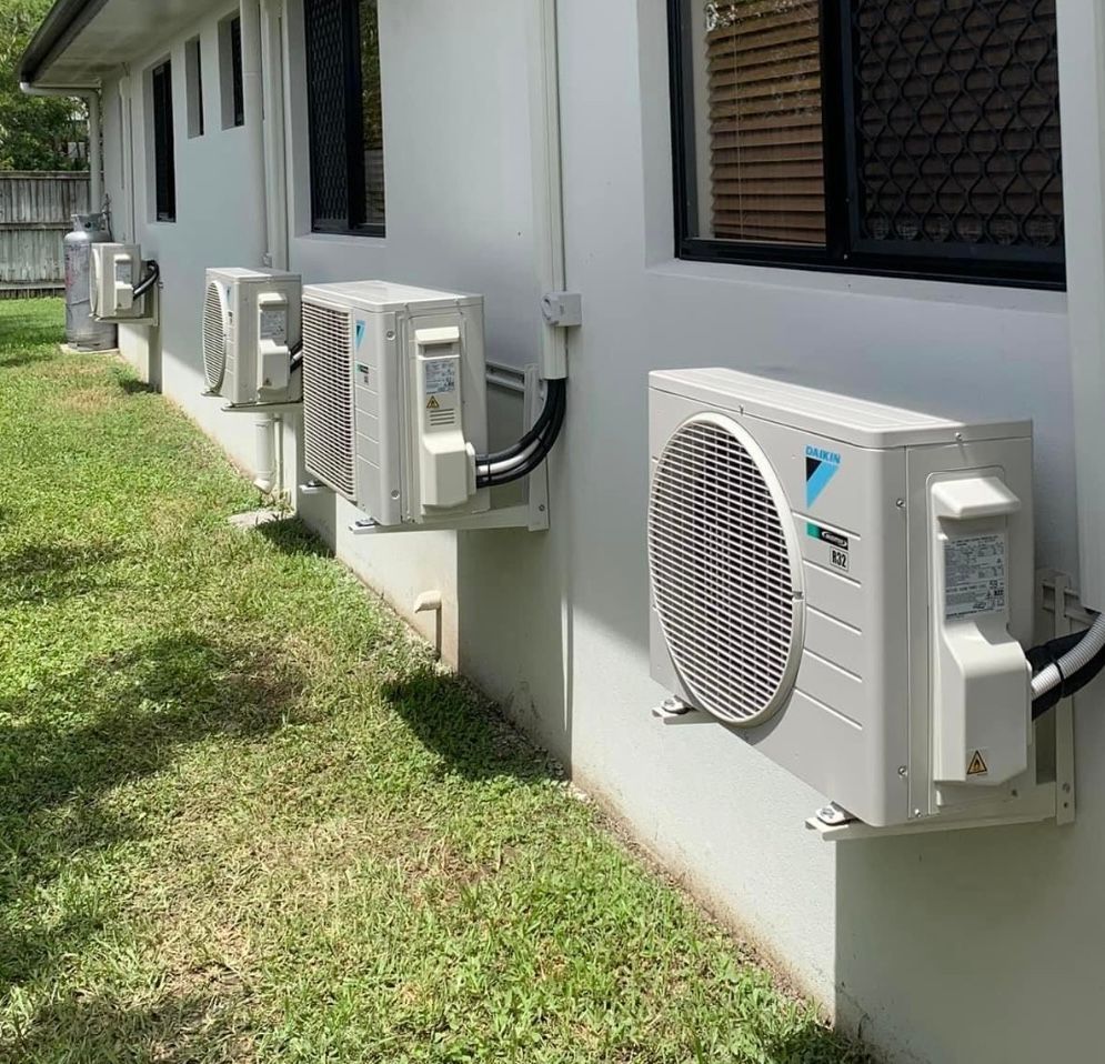 A White House With A Lot Of Air Conditioners On The Side Of It — Law Air Conditioning In Annandale, QLD